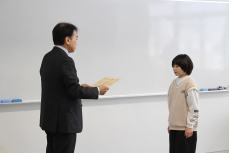 谷口税務署長から田畑さんへ賞状の手渡し