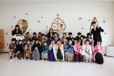 式の前、集合写真を撮る卒園児と担任の先生