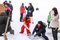 バケツに雪を入れる子ども