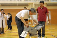 いざ模擬投票へ、最初に投票に来た方は投票箱に異常がないかチェック