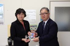 防犯ブザーの現物を手渡す渡邊氏と受け取る岸教育長