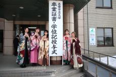 大学前で写真を撮る卒業生