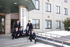 大学入り口で写真を撮る卒業生